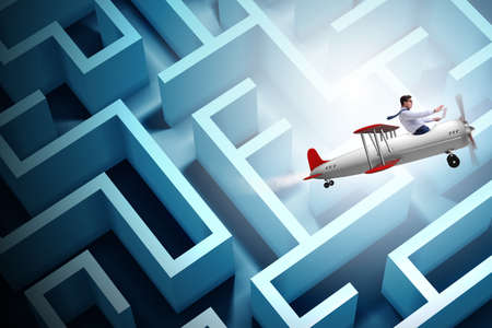 Businessman escaping from maze on airplaneの写真素材