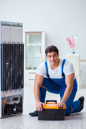 Repairman contractor repairing fridge in DIY conceptの写真素材