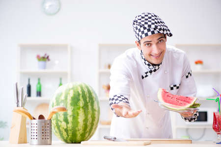Male cook with watermelon in kitchenの写真素材