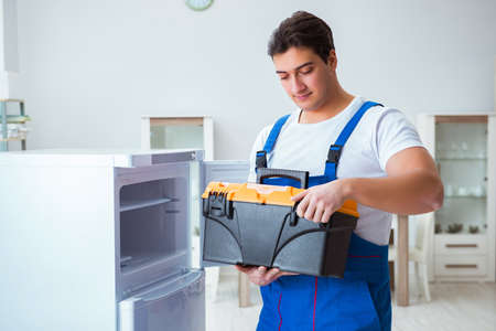 Repairman contractor repairing fridge in DIY conceptの写真素材