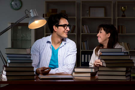 Two students studying late preparing for examsの写真素材