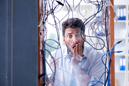 Electrician trying to untangle wires in repair conceptの写真素材