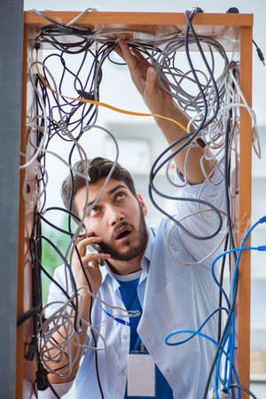Electrician trying to untangle wires in repair conceptの写真素材