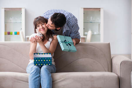 Young woman getting pet rabbit as birthday presentの写真素材