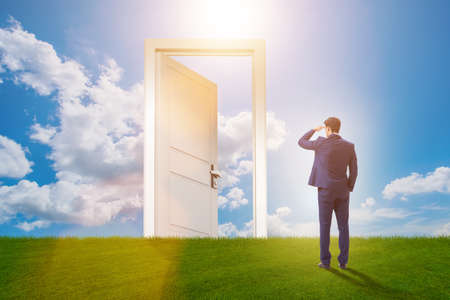 Businessman standing in front of door into futureの写真素材