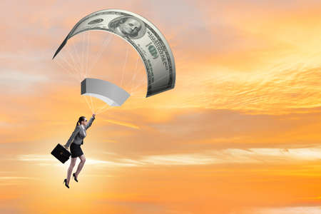 Businesswoman in golden parachute conceptの写真素材