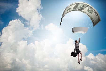 Businesswoman in golden parachute conceptの写真素材