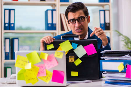 Businessman with reminder notes in multitasking conceptの写真素材