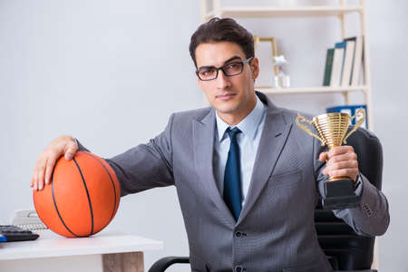 Businessman with prize cup for achievements in officeの写真素材
