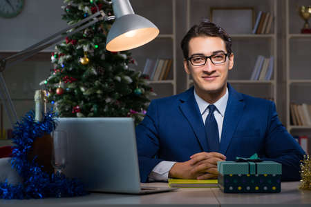 Businessman working late on christmas day in officeの写真素材
