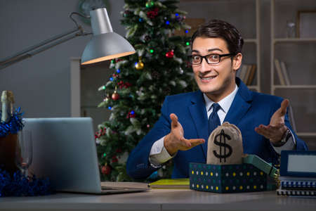 Businessman working late on christmas day in officeの写真素材