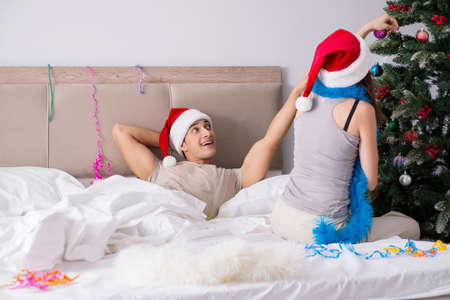 Young happy family celebrating christmas in bedの写真素材