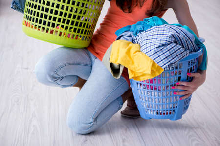 Stressed woman doing laundry at homeの写真素材