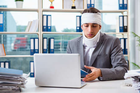 Injured businessman working in the officeの写真素材