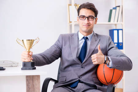 Businessman with prize cup for achievements in officeの写真素材
