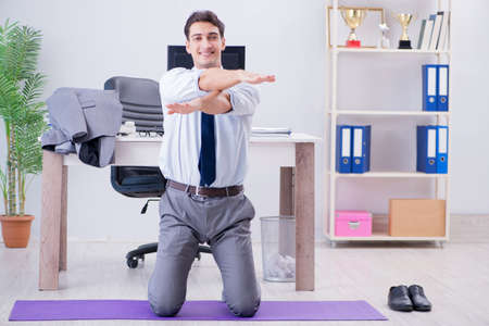 Businessman doing sports in office during breakの写真素材