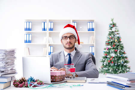 Young businessman celebrating christmas in the officeの写真素材