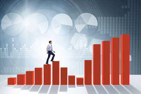 Businessman going up the bar chart in growth conceptの写真素材