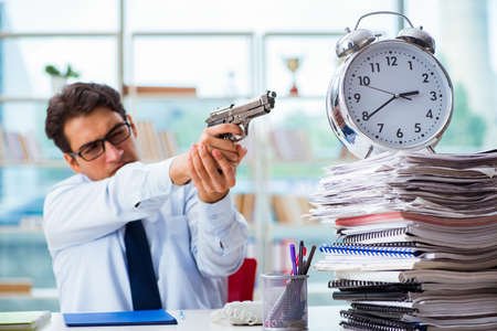 Angry businessman with gun thinking of committing suicideの写真素材