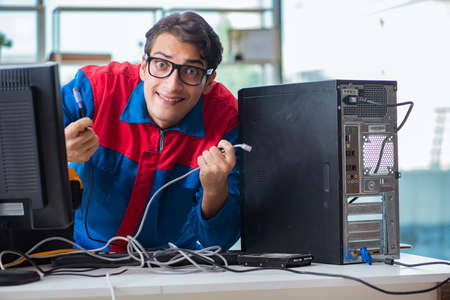 Computer repairman working on repairing computer in IT workshopの写真素材