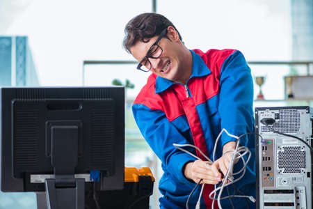 Computer repairman working on repairing computer in IT workshop