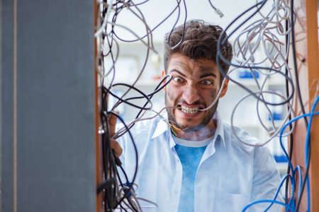 Computer repairman working on repairing network in IT workshopの写真素材