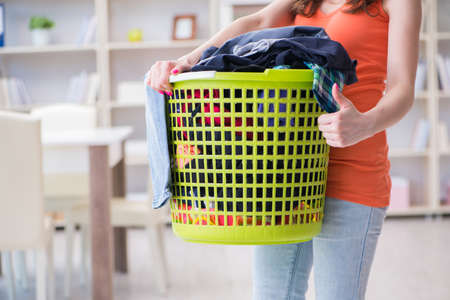 Stressed woman doing laundry at homeの写真素材
