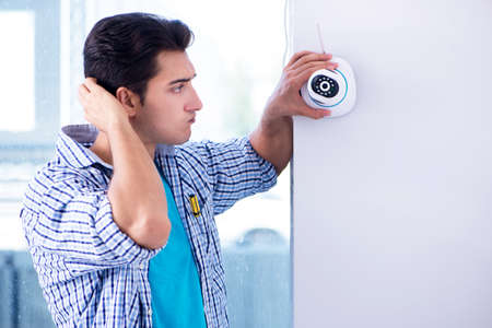 Man installing surveillance CCTV cameras at home