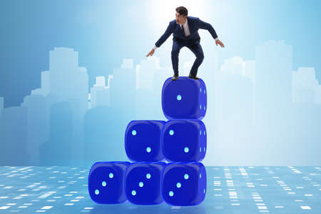 Businessman balancing on top of dice stack in uncertainty concepの写真素材