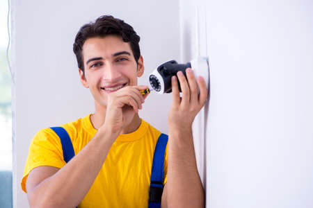 Contractor installing surveillance CCTV cameras in officeの写真素材