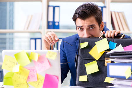 Businessman with reminder notes in multitasking conceptの写真素材