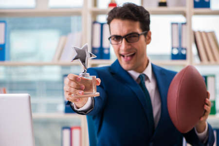 Businessman with american football in officeの写真素材