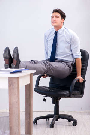 Businessman doing sports in office during breakの写真素材