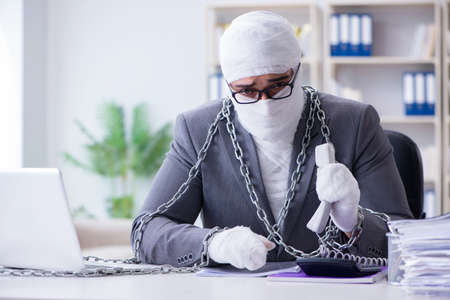 Bandaged businessman worker working in the office doing paperworの写真素材