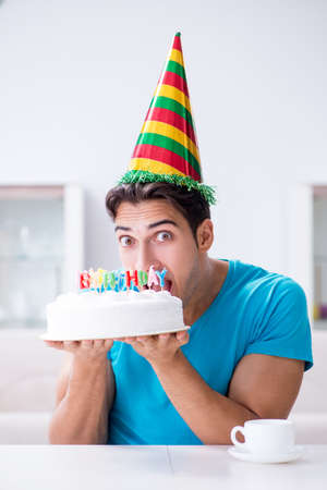 Young man celebrating birthday alone at homeの写真素材