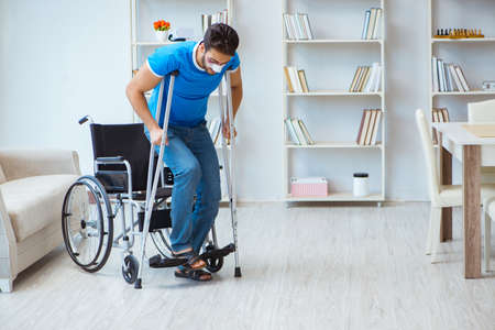 Young man recovering after surgery at home with crutches and a w