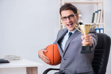 Businessman with prize cup for achievements in officeの写真素材