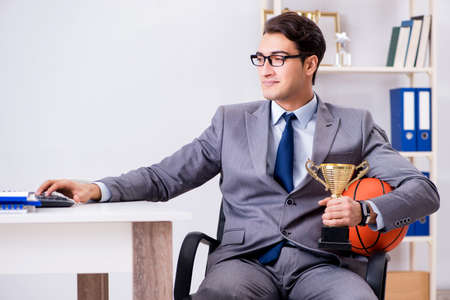Businessman with prize cup for achievements in officeの写真素材