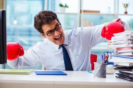 Businessman with boxing gloves in the officeの写真素材