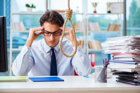 Unhappy businessman thinking of hanging himself in the officeの写真素材