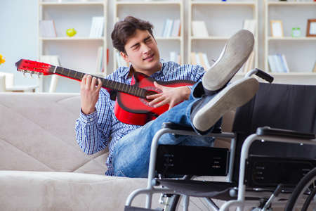 Disabled man playing guitar at homeの写真素材