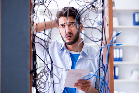 Computer repairman working on repairing network in IT workshopの写真素材