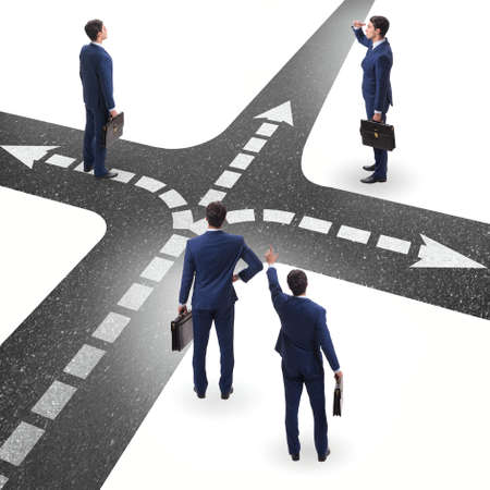 Young businessman at crossroads in uncertainty conceptの写真素材