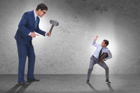 Bad angry boss threatening employee with hammerの写真素材