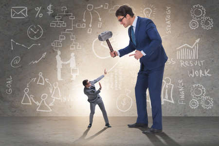 Bad angry boss threatening employee with hammerの写真素材