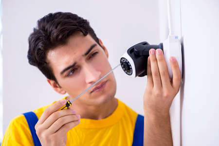 Contractor installing surveillance CCTV cameras in officeの写真素材