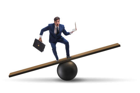 Businessman balancing on seesaw in uncertainty conceptの写真素材
