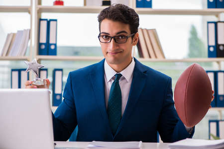Businessman with american football in officeの写真素材