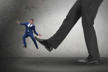 Bad angry boss kicking employee in business concept