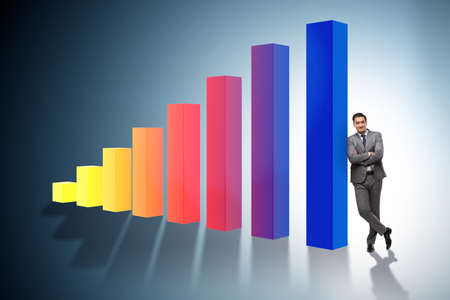 Young businessman in business concept with bar chartsの写真素材